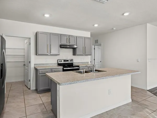 a kitchen with a stove a sink and a refrigerator