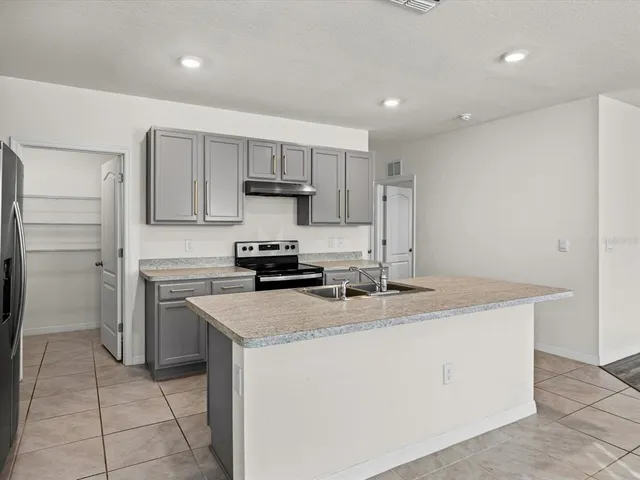a kitchen with a stove a sink and a refrigerator