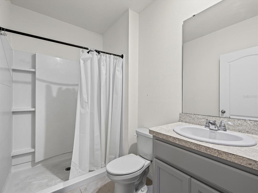 4223 San Rocco Way Winter Haven, FL 33884 - Photo 16 of 47 a bathroom with a granite countertop sink toilet and shower
