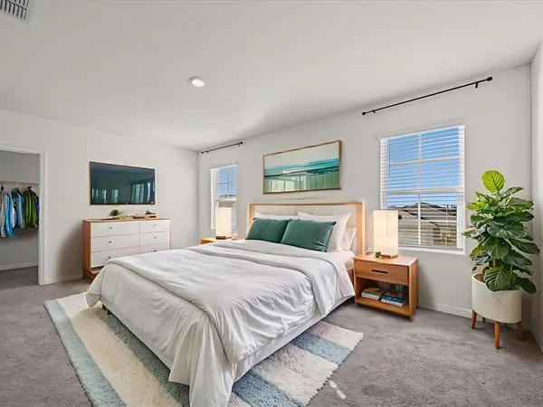 a bedroom with a bed and a potted plant