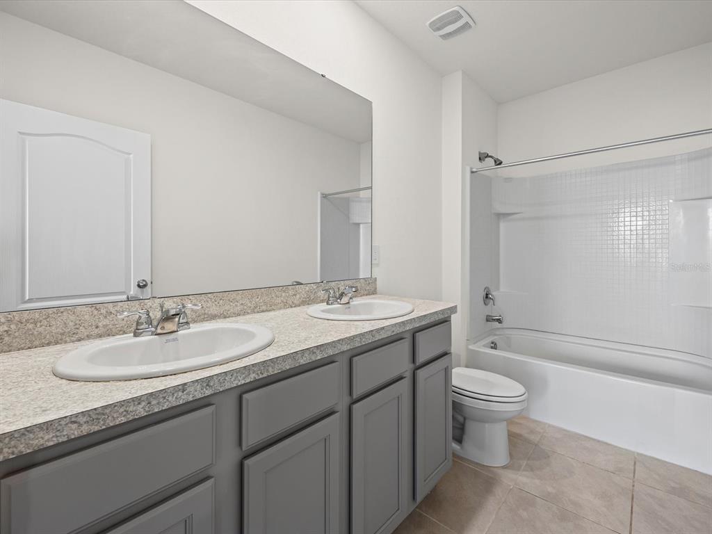 4223 San Rocco Way Winter Haven, FL 33884 - Photo 32 of 47 a bathroom with a granite countertop sink toilet and shower