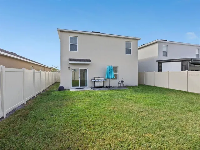 a backyard of a house with table and chairs