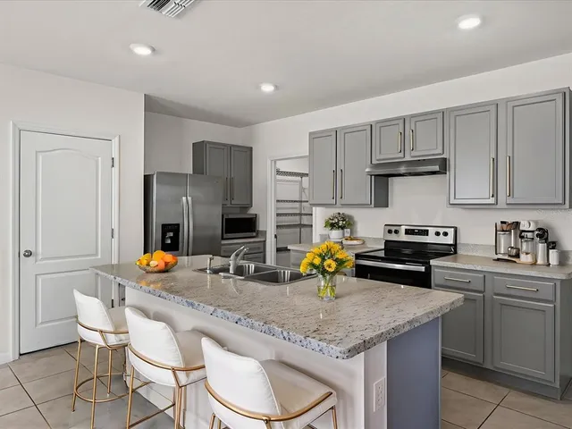 a kitchen with a sink a stove and chairs
