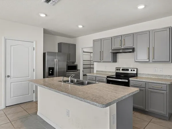 a kitchen with stainless steel appliances granite countertop a sink stove and refrigerator