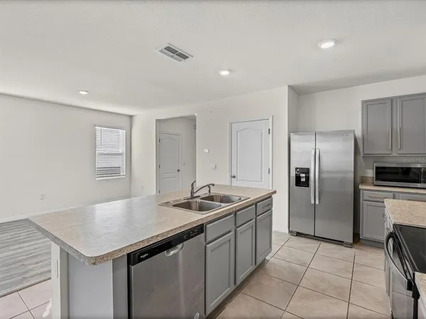 a kitchen with stainless steel appliances granite countertop a sink refrigerator and cabinets