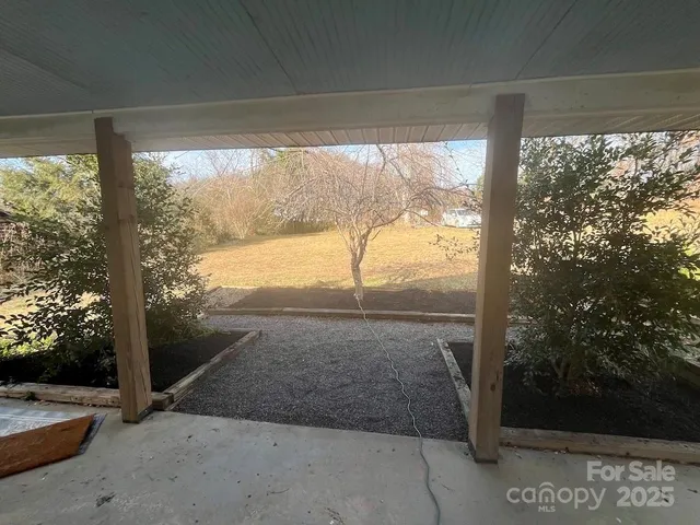 a bed sitting in a spacious bedroom next to a window
