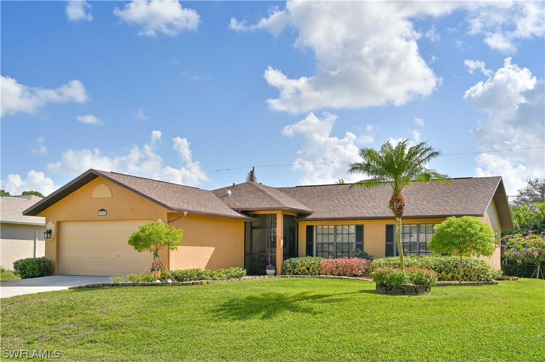 9092 Morris Road Fort Myers, FL 33967 - Photo 1 of 28 a front view of a house with a garden and yard