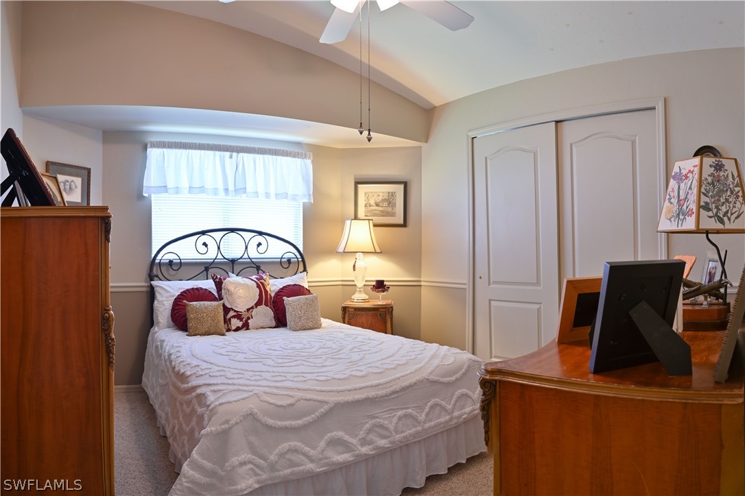 9092 Morris Road Fort Myers, FL 33967 - Photo 20 of 28 a bedroom with a bed a mirror on dresser and a large window