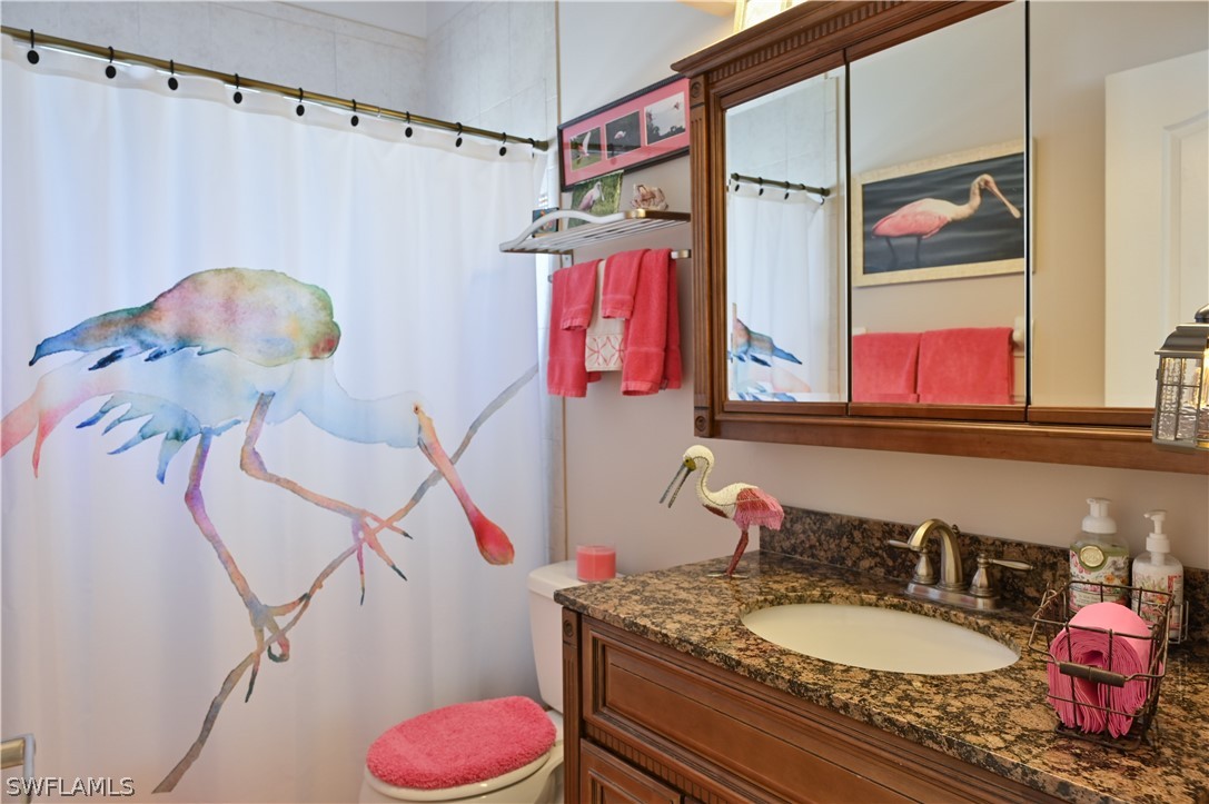 9092 Morris Road Fort Myers, FL 33967 - Photo 22 of 28 a bathroom with a granite countertop sink a mirror and shower curtain