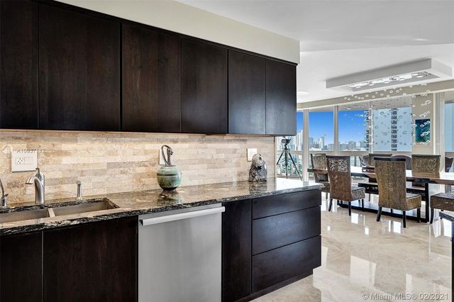 a bathroom with a granite countertop sink a mirror and a toilet
