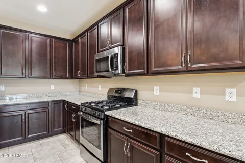 a kitchen with stainless steel appliances granite countertop a sink refrigerator and cabinets