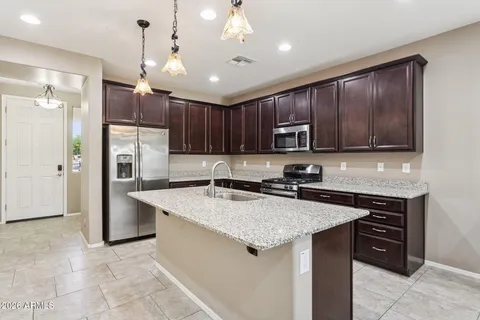 a kitchen with stainless steel appliances granite countertop a stove refrigerator sink microwave and cabinets