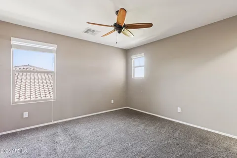 an empty room with a window and ceiling fan