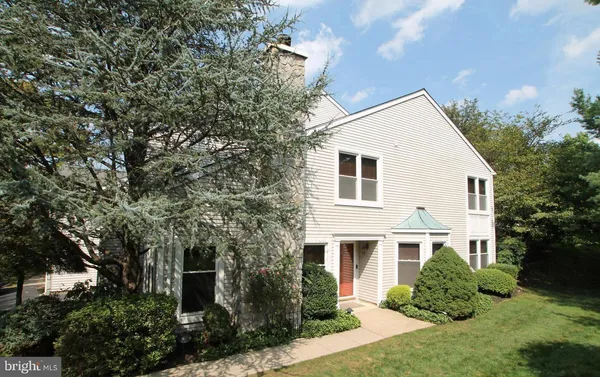 a view of a white house with a big yard and potted plants