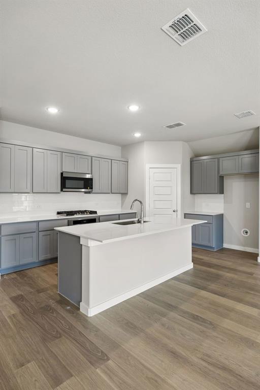 1456 Companero Street Haslet, TX 76052 - Photo 9 of 33 a large kitchen with stainless steel appliances granite countertop a stove a sink and white cabinets