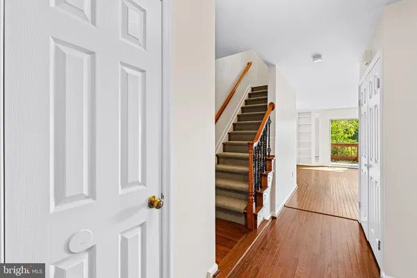 a view of a hallway with wooden floor and staircase