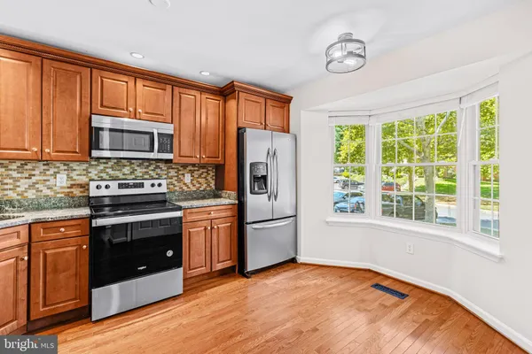 a kitchen with stainless steel appliances granite countertop a refrigerator stove top oven and sink