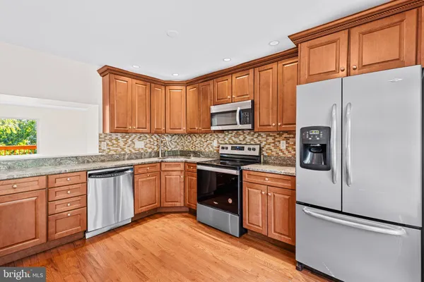 a kitchen with stainless steel appliances granite countertop a refrigerator sink and cabinets
