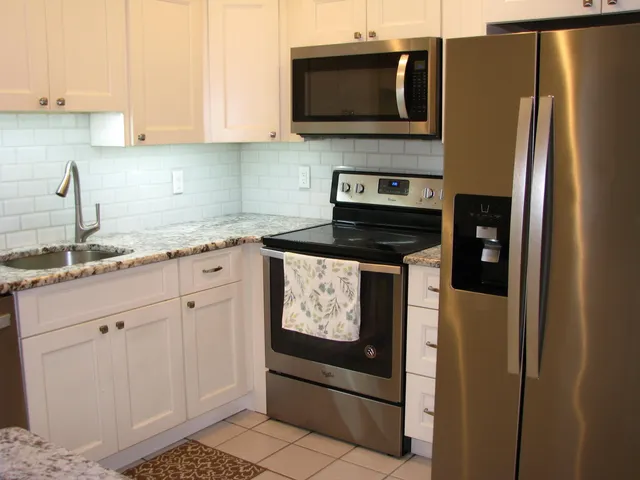 a kitchen with stainless steel appliances granite countertop a refrigerator stove and microwave