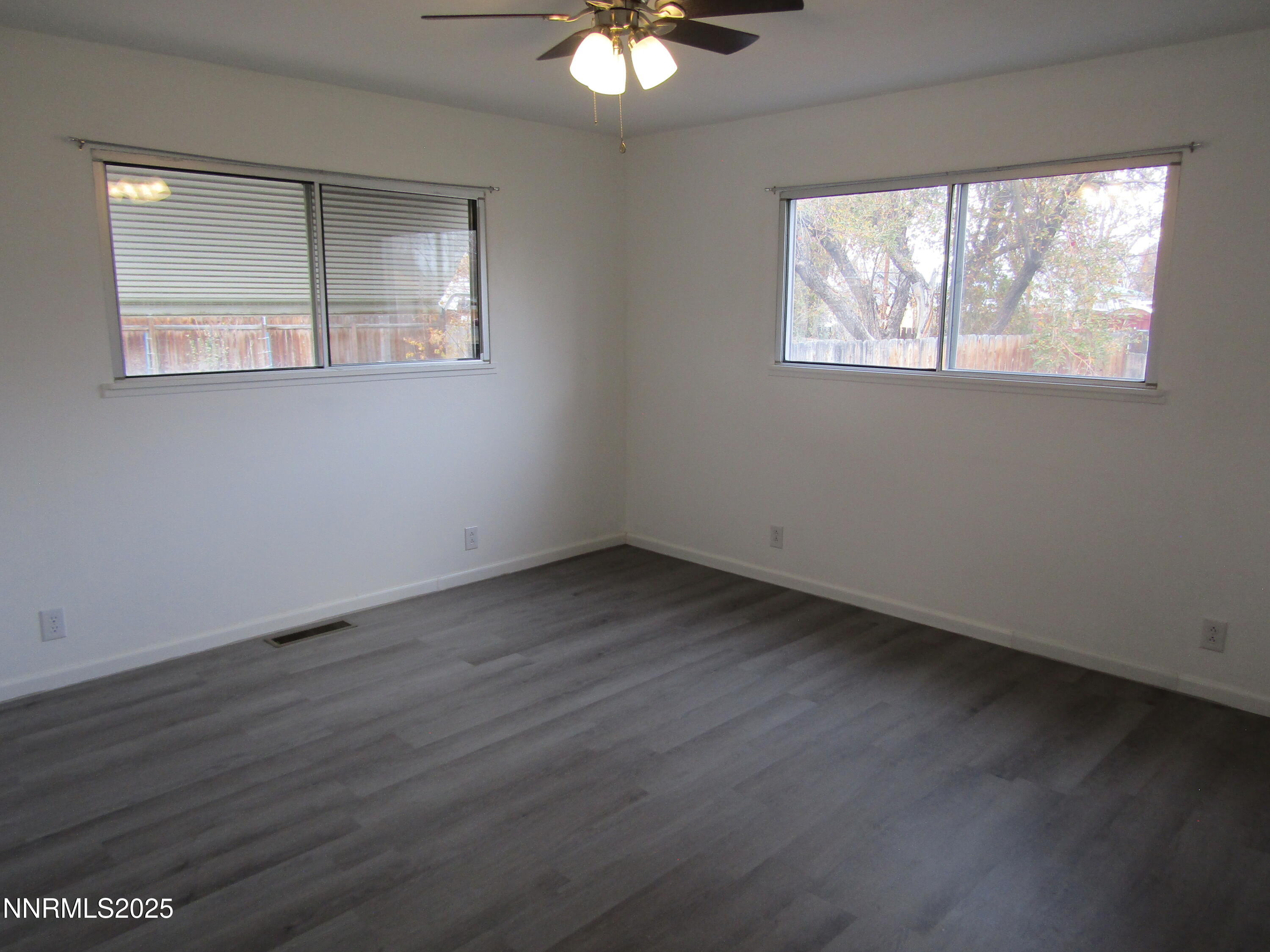 111 South Whitacre Street Yerington, NV 89447 - Photo 13 of 30 an empty room with wooden floor and windows