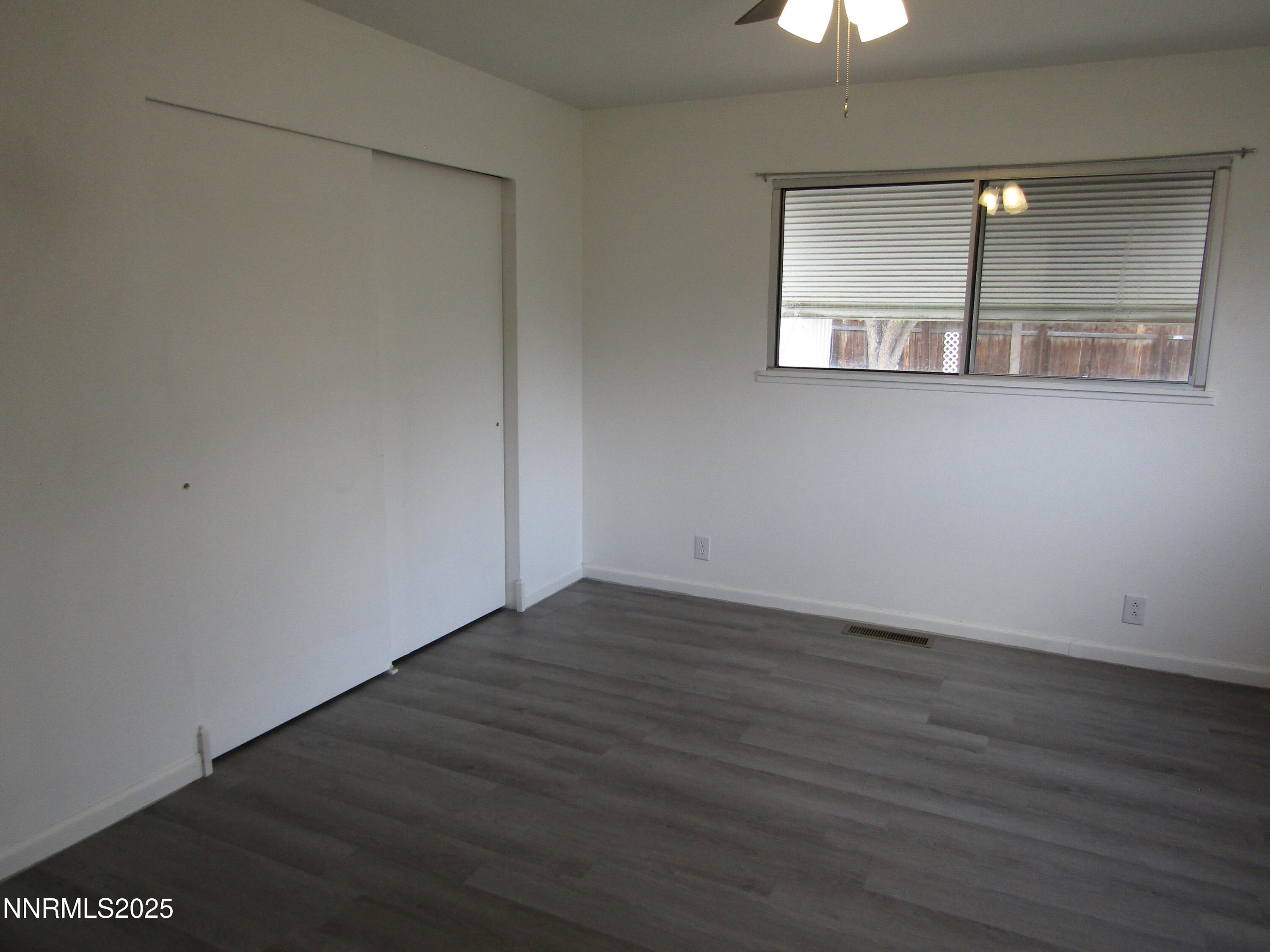 111 South Whitacre Street Yerington, NV 89447 - Photo 14 of 30 an empty room with wooden floor and windows