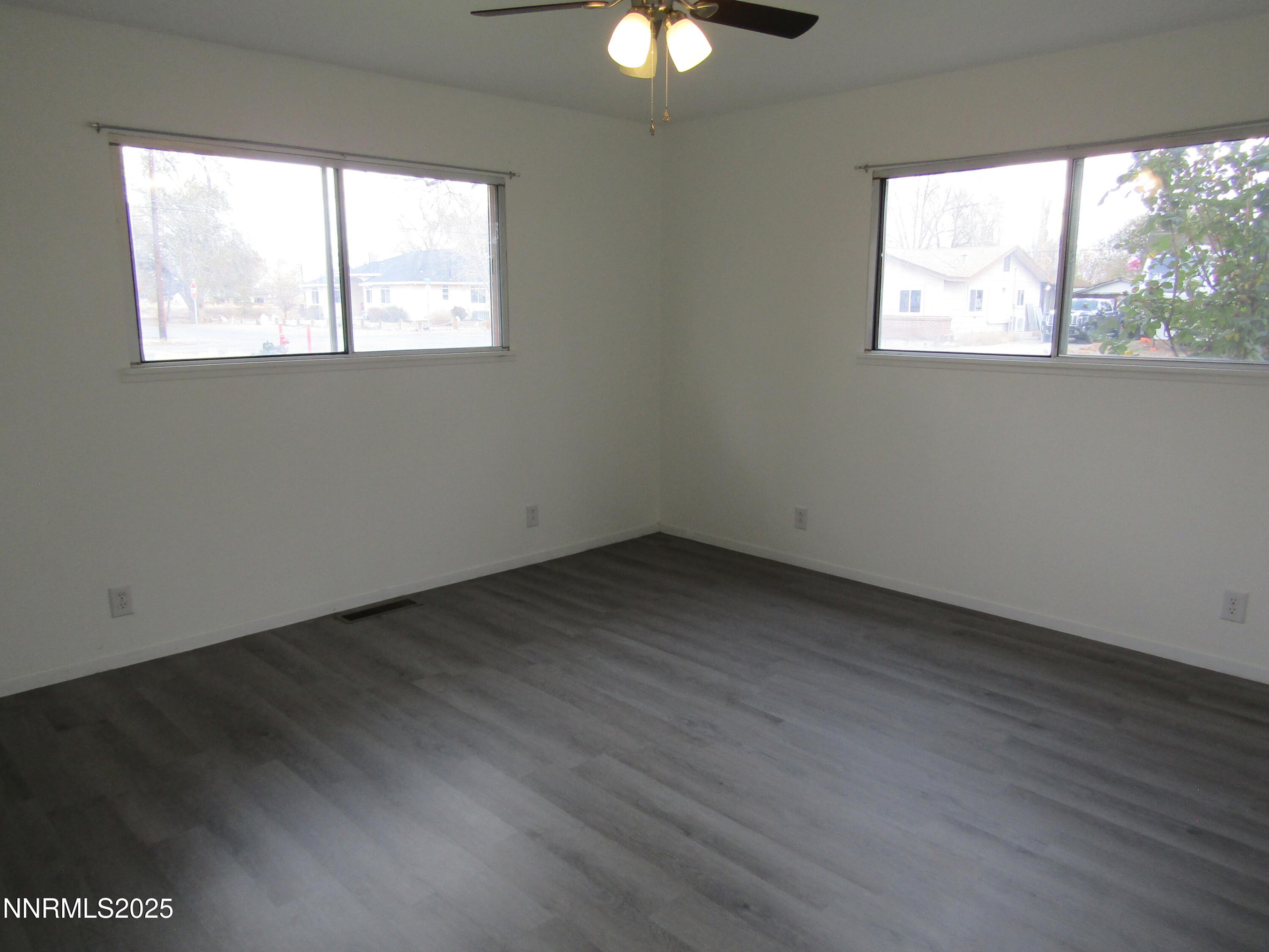 111 South Whitacre Street Yerington, NV 89447 - Photo 18 of 30 an empty room with wooden floor and windows