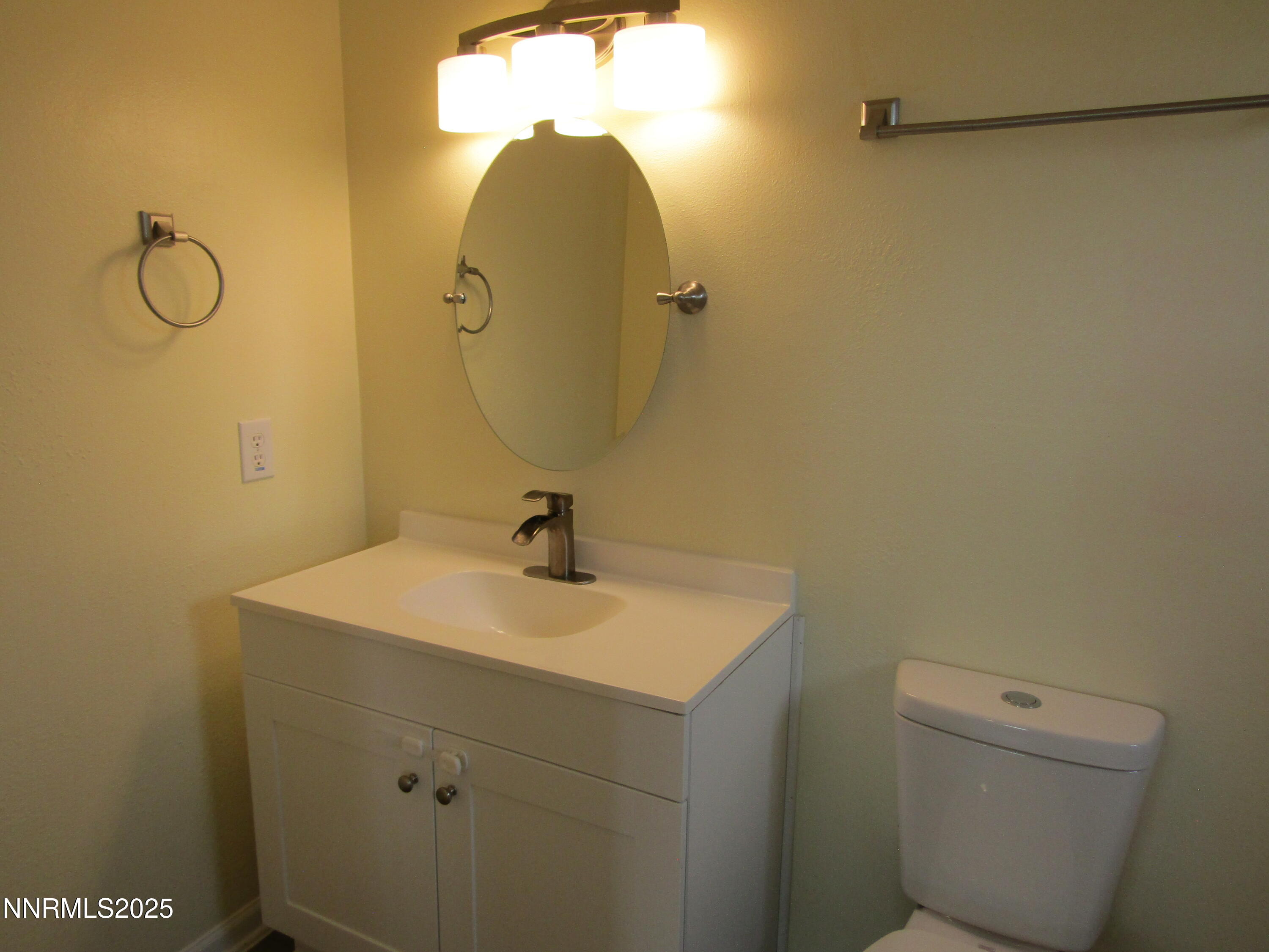 111 South Whitacre Street Yerington, NV 89447 - Photo 20 of 30 a bathroom with a sink and mirror with toilet
