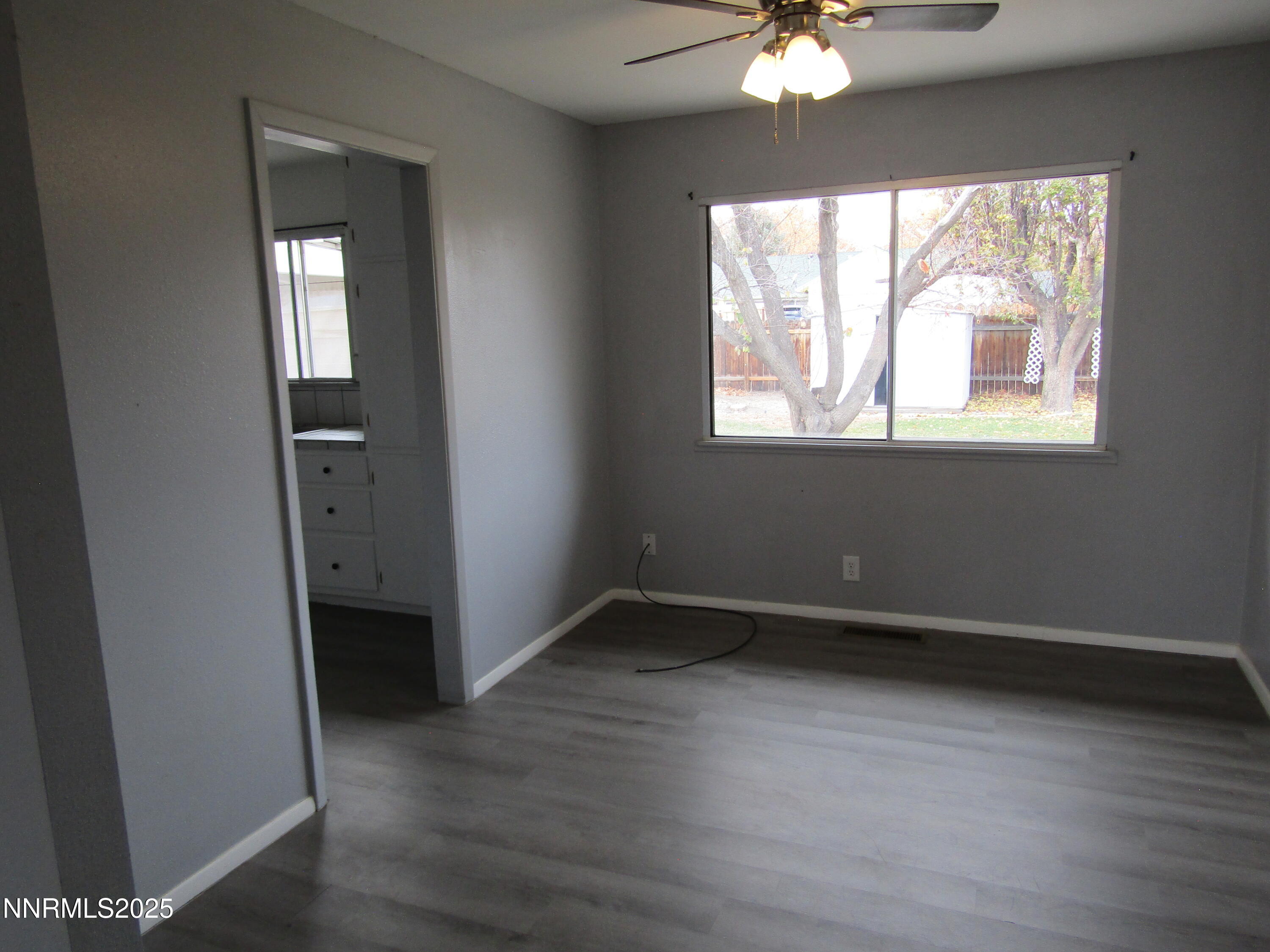 111 South Whitacre Street Yerington, NV 89447 - Photo 6 of 30 a view of an empty room with wooden floor and a window
