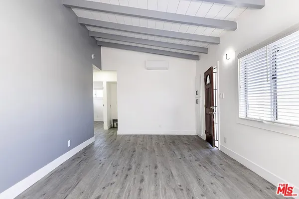 a view of a room with wooden floor and a window