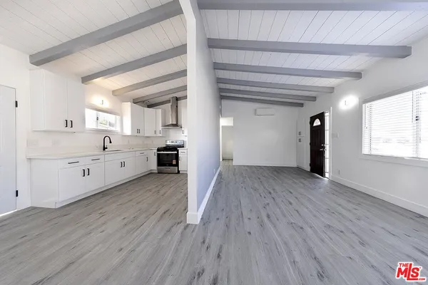 a view of a kitchen with wooden floor and windows