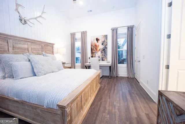 a spacious bedroom with a bed and wooden floor