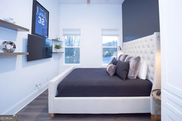 a large bed sitting in a bedroom next to a window with tv