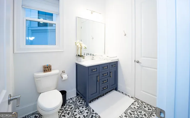 a bathroom with a sink a toilet and mirror