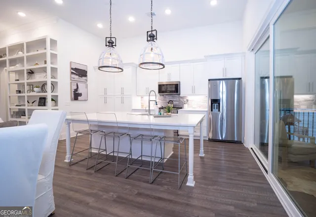 a kitchen with stainless steel appliances kitchen island granite countertop a kitchen island hardwood floor and a sink