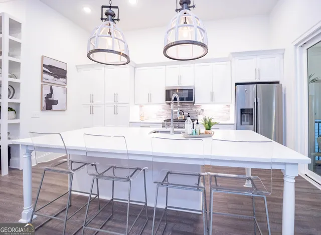 a kitchen with stainless steel appliances a table chairs and chandelier