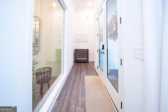 a view of a hallway with wooden floor and a bathroom