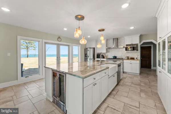 a large kitchen with stainless steel appliances kitchen island granite countertop a refrigerator and a stove top oven