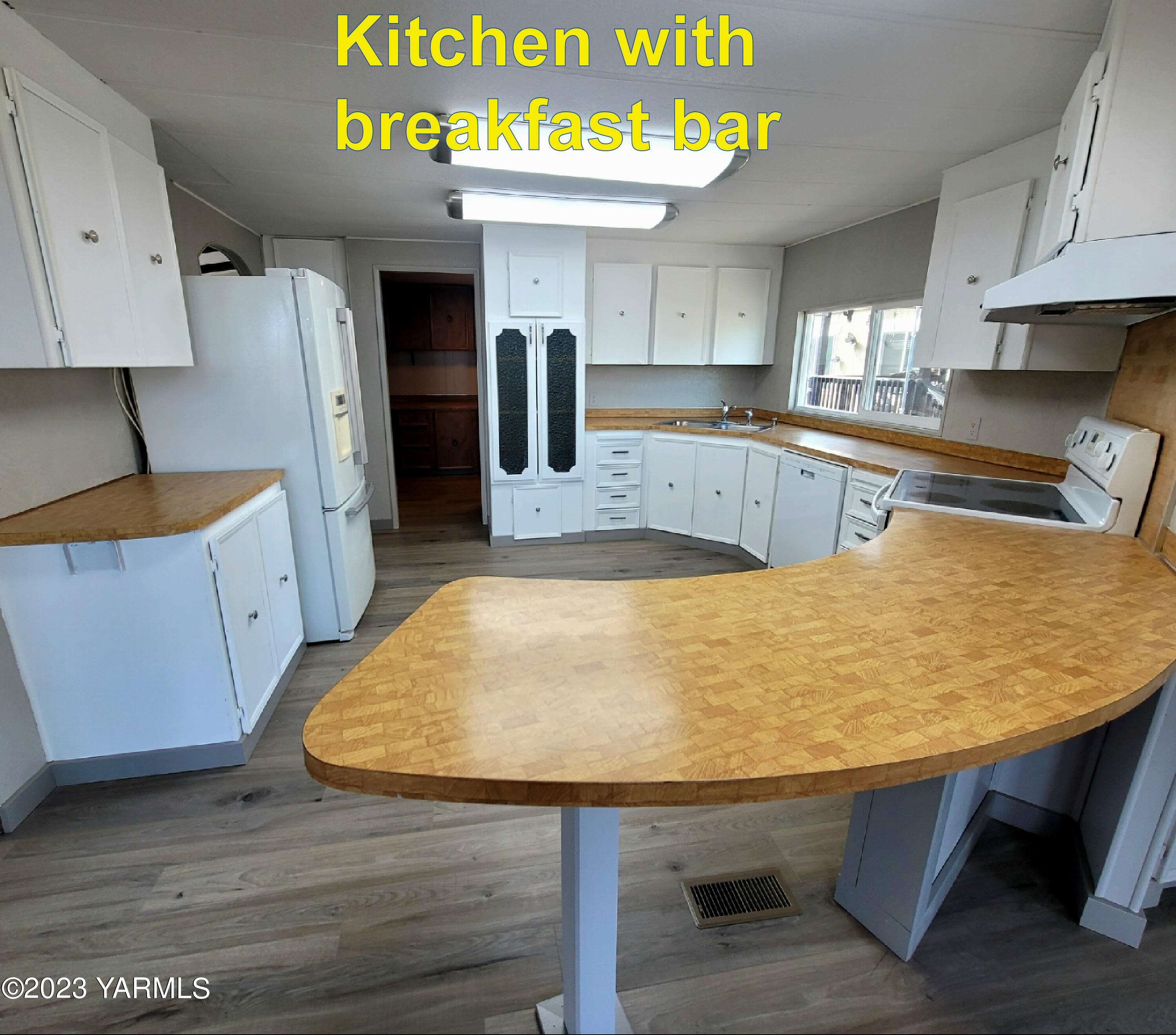 3005 Castlevale Road, Unit 50 Yakima, WA 98902 - Photo 5 of 16 a room with kitchen island a wooden floor and stainless steel appliances