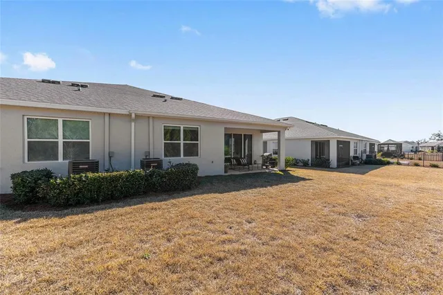 a front view of a house with a yard and potted plants