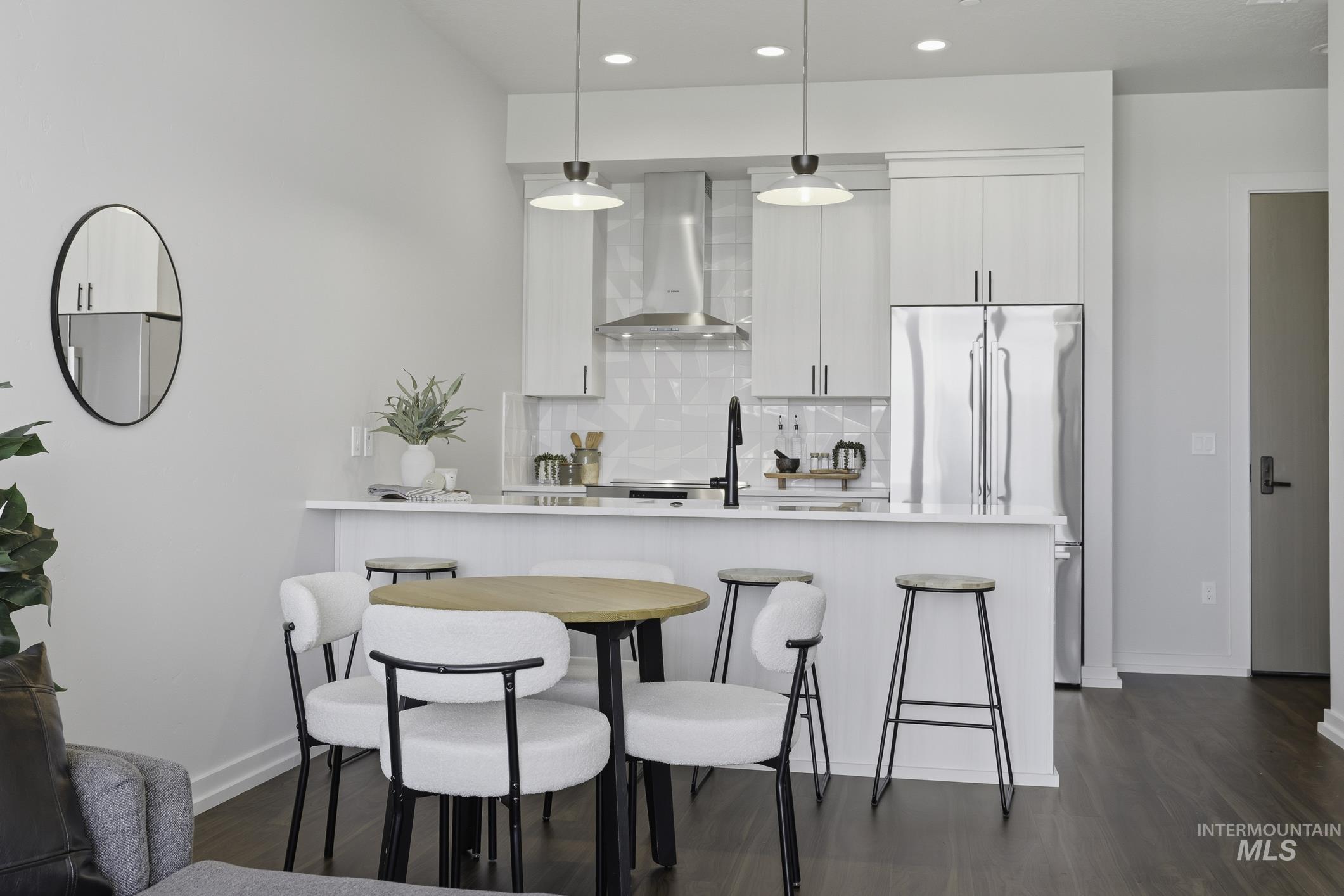 4250 East Haystack Street, Unit 308 Boise, ID 83716 - Photo 12 of 27 Kitchen featuring a breakfast bar, dark wood finished floors, pendant lighting, backsplash, and built in fridge
