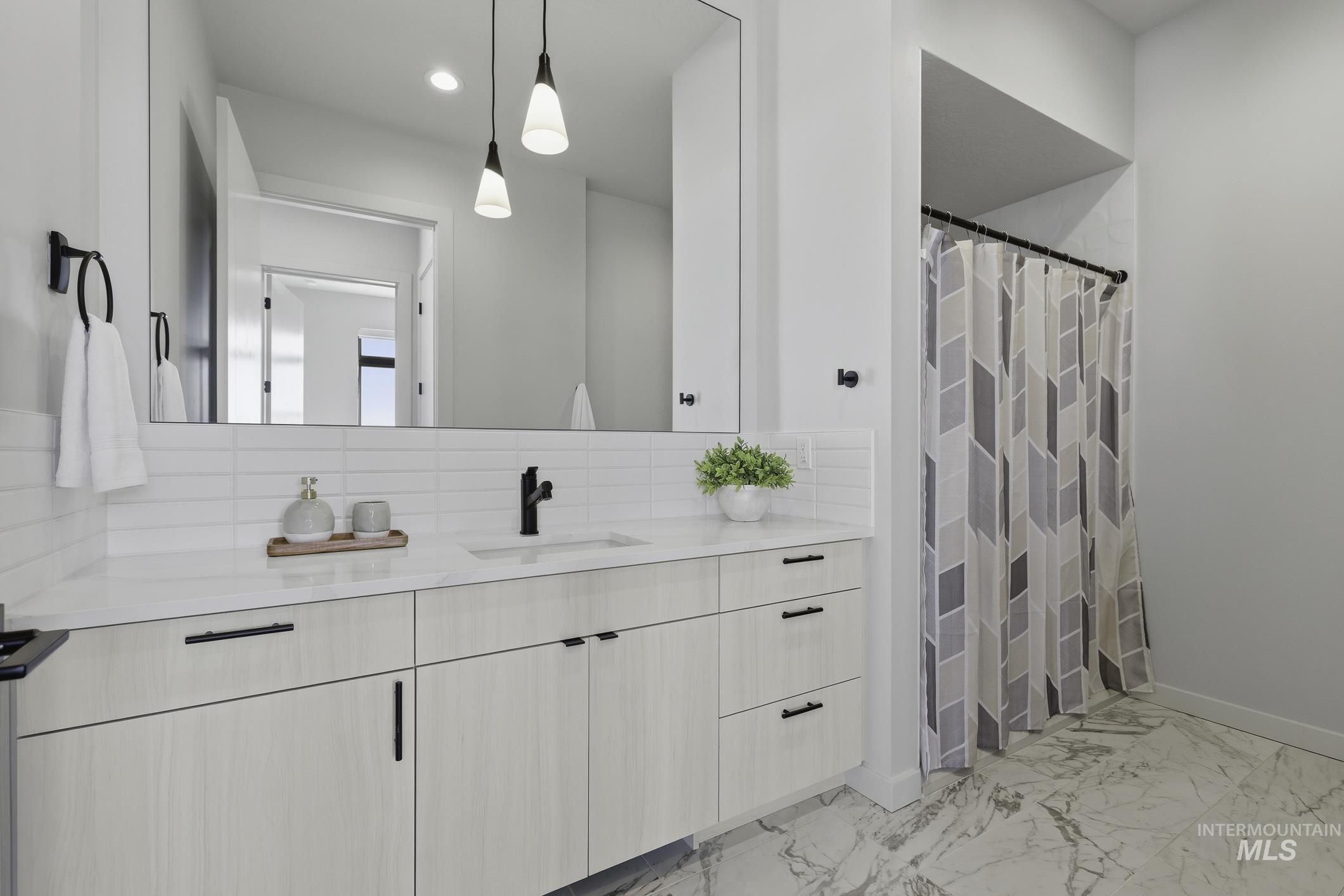 4250 East Haystack Street, Unit 308 Boise, ID 83716 - Photo 15 of 27 Bathroom with a shower with curtain, vanity, light marble finish flooring, decorative backsplash, and recessed lighting