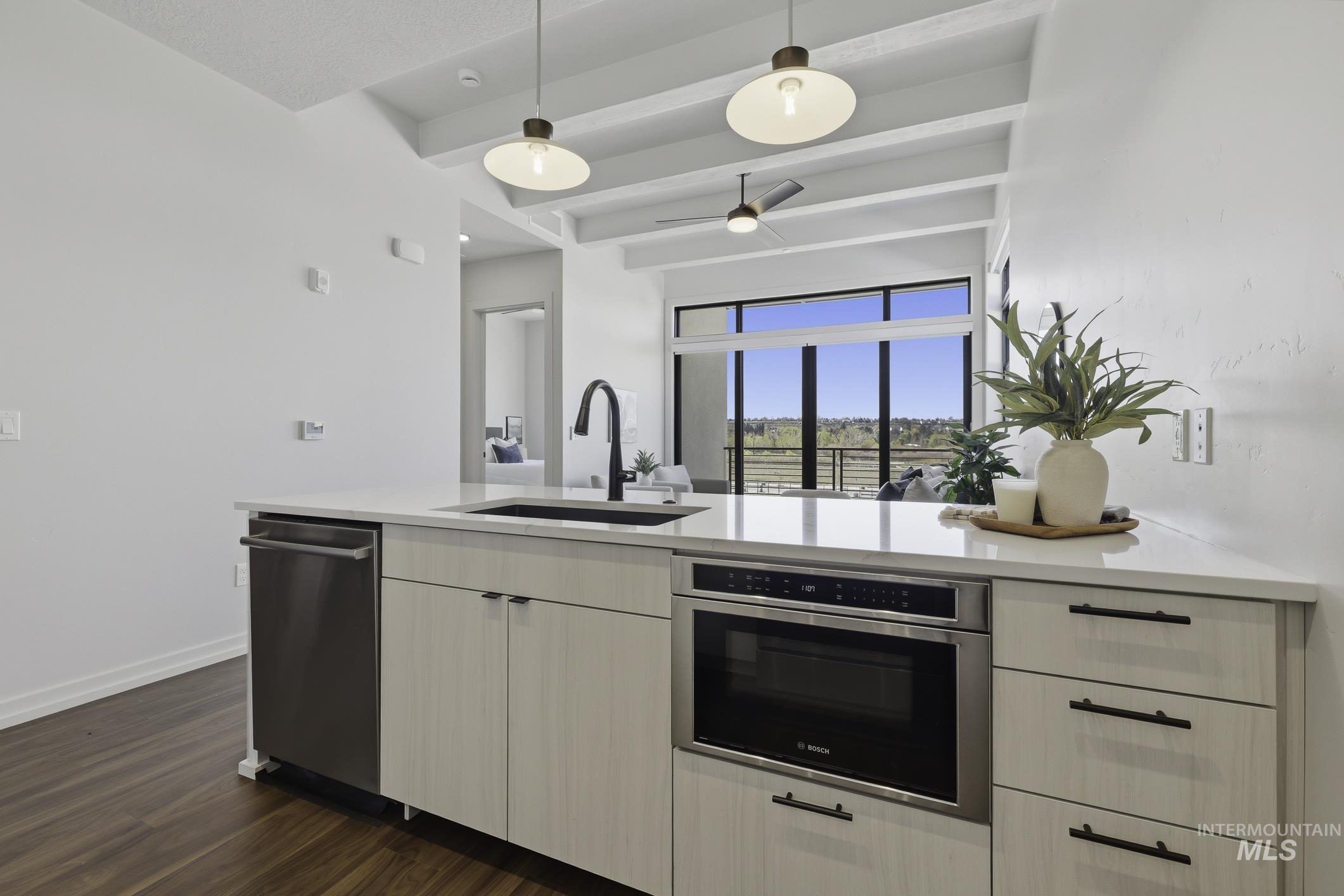 4250 East Haystack Street, Unit 308 Boise, ID 83716 - Photo 10 of 27 Kitchen with decorative light fixtures, stainless steel appliances, a peninsula, light stone countertops, and a ceiling fan