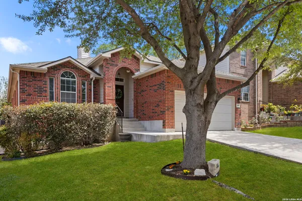 a front view of a house with a yard and tree