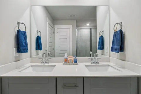 a bathroom with double sink and a mirror