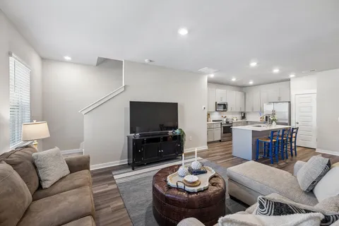 a living room with furniture kitchen view and a flat screen tv