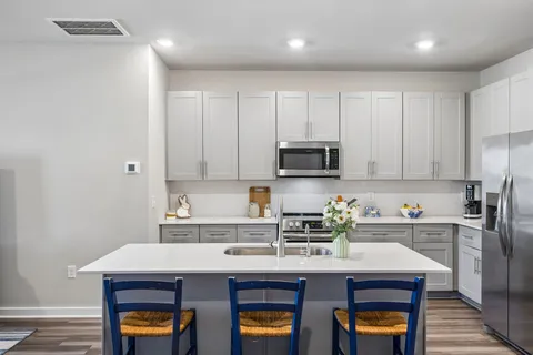 a kitchen with stainless steel appliances a stove a sink and a refrigerator