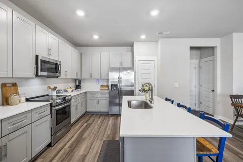 a kitchen with sink a microwave and cabinets