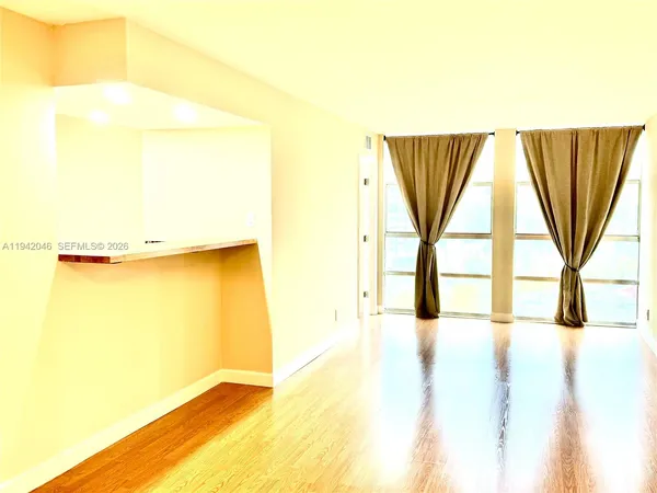 a view of a room with a window and a bed