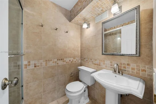 a bathroom with a toilet sink and mirror