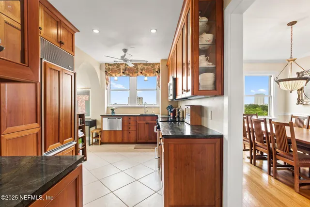 a kitchen with stainless steel appliances granite countertop a refrigerator a stove and a sink with cabinets
